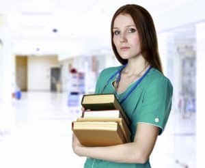 Pretty nurse or doctor with books in a corridor of a hospital or medical college